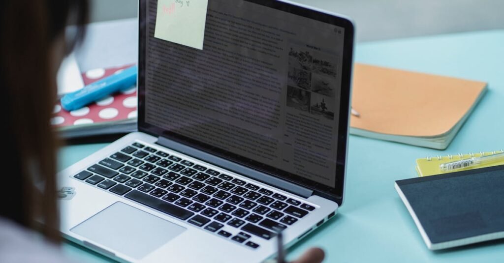 A student working on a laptop with notebooks, focusing on studying.